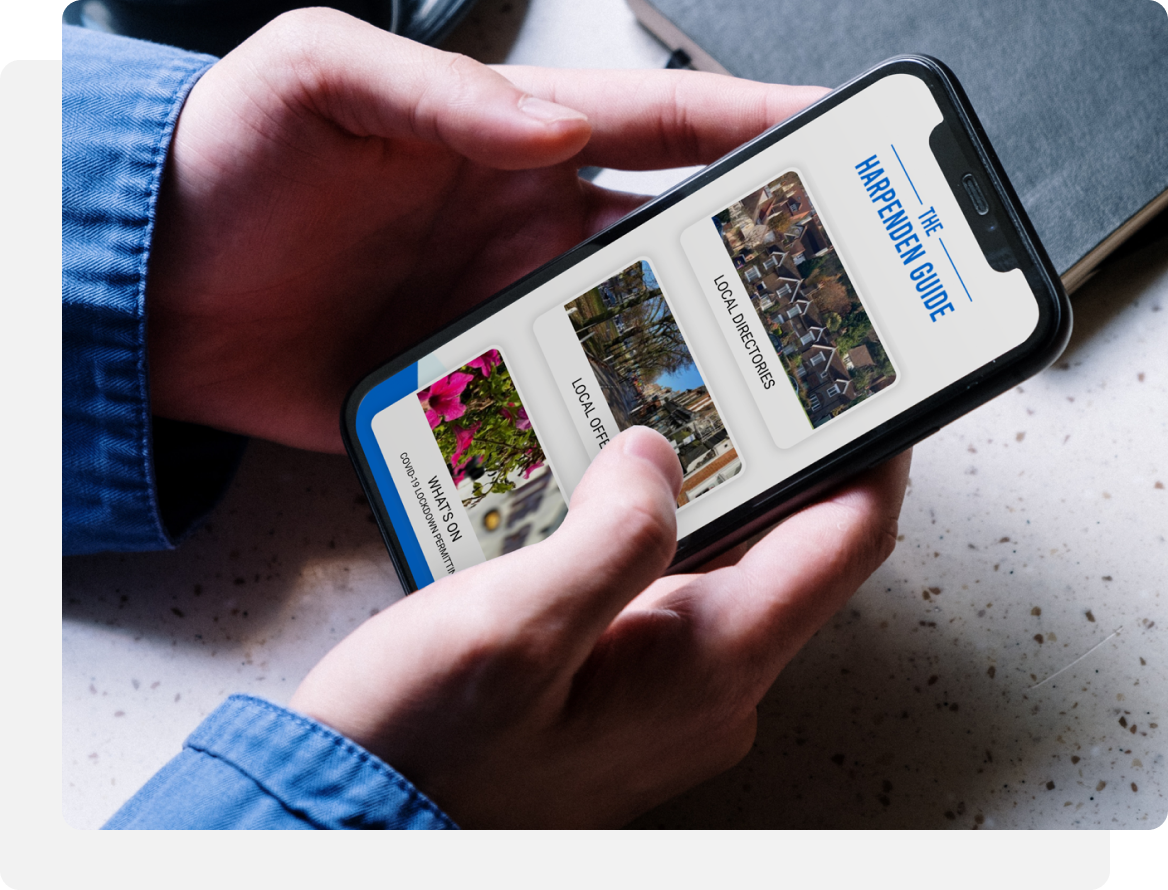 Person holding phone, browsing a travel guide with photo thumbnails.