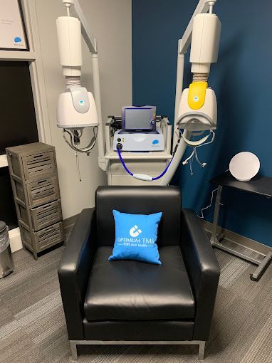 A chair with a blue pillow on it in a room with a machine.