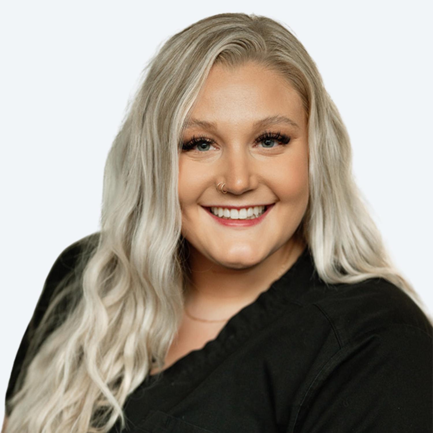 A woman with blonde hair is wearing a black shirt and smiling.