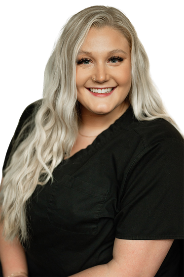 A woman with long blonde hair is wearing a black scrub top and smiling.