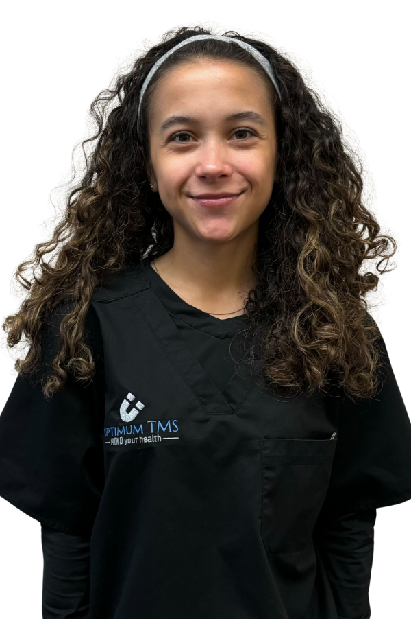 A woman with curly hair is wearing a headband and a black scrub top.