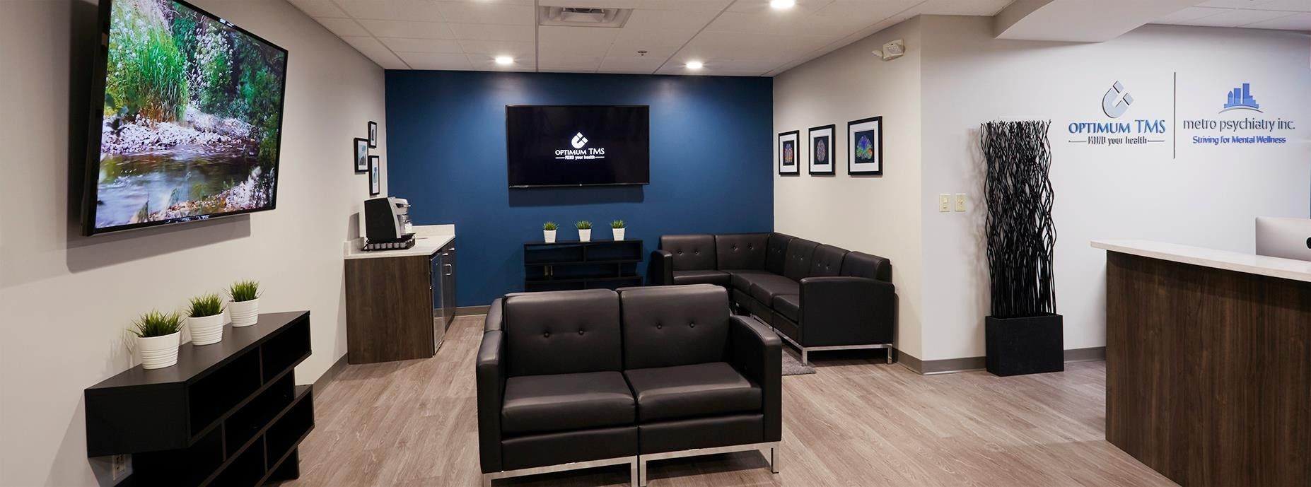 A waiting room with a couch , chairs and a flat screen tv.