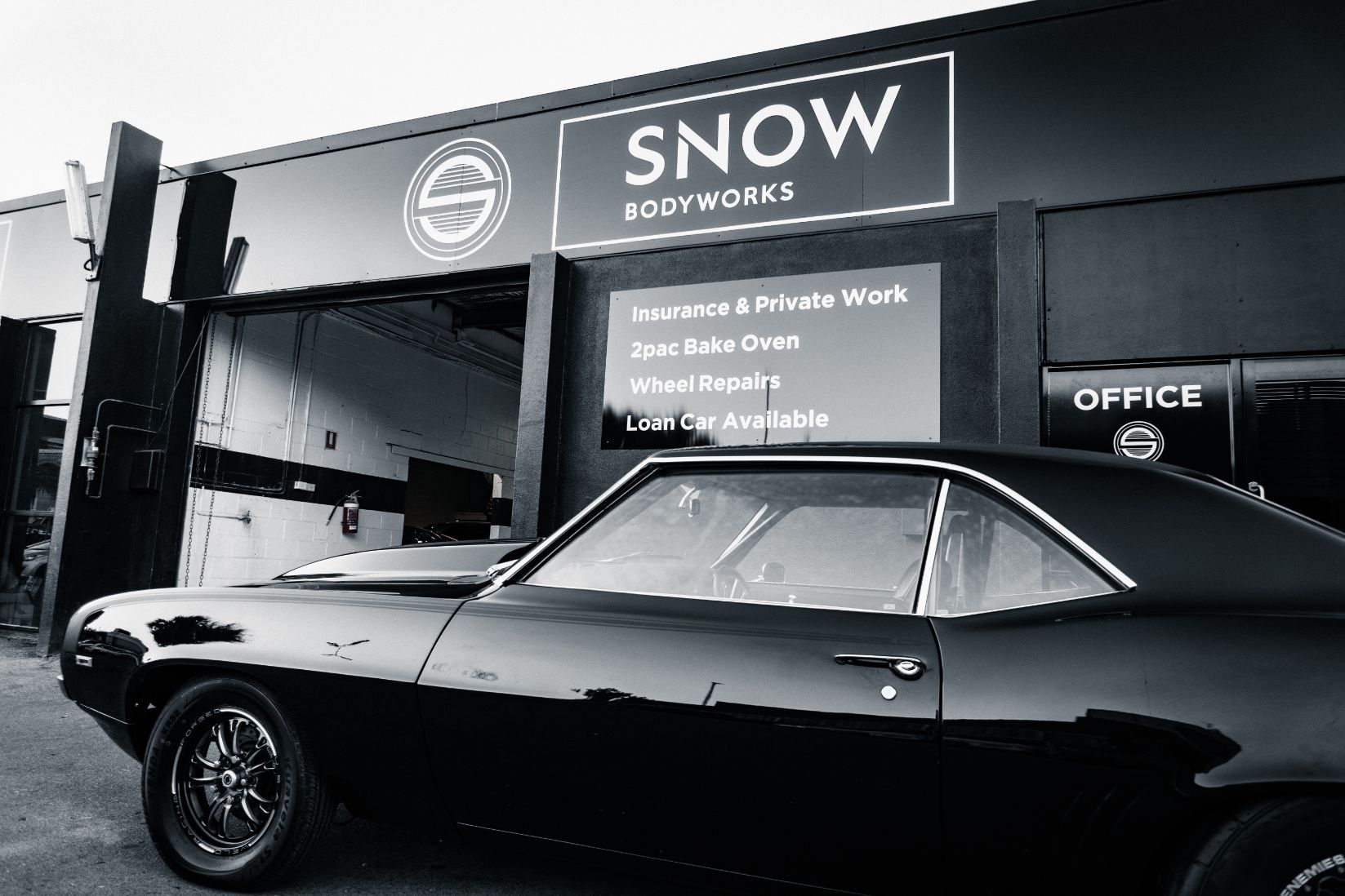 Modern Black Car Outside Workshop  — Panel Beaters in Southport, QLD