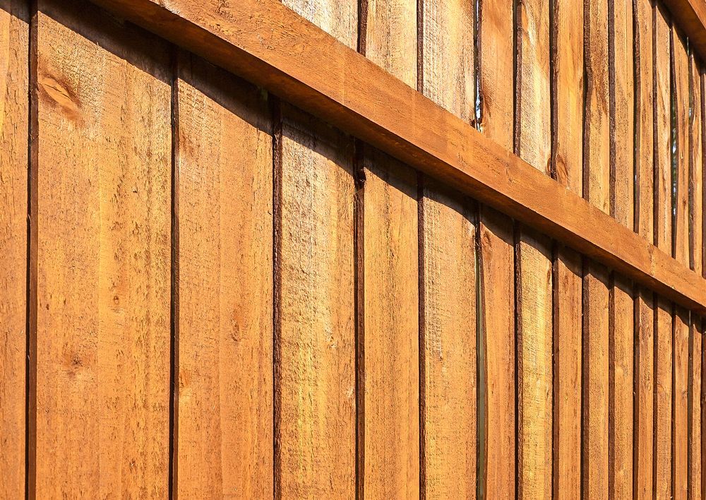 a close up of a wooden fence with a shadow on it