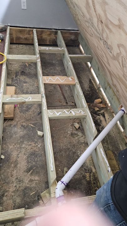 A ladder is sitting in front of a house under construction.