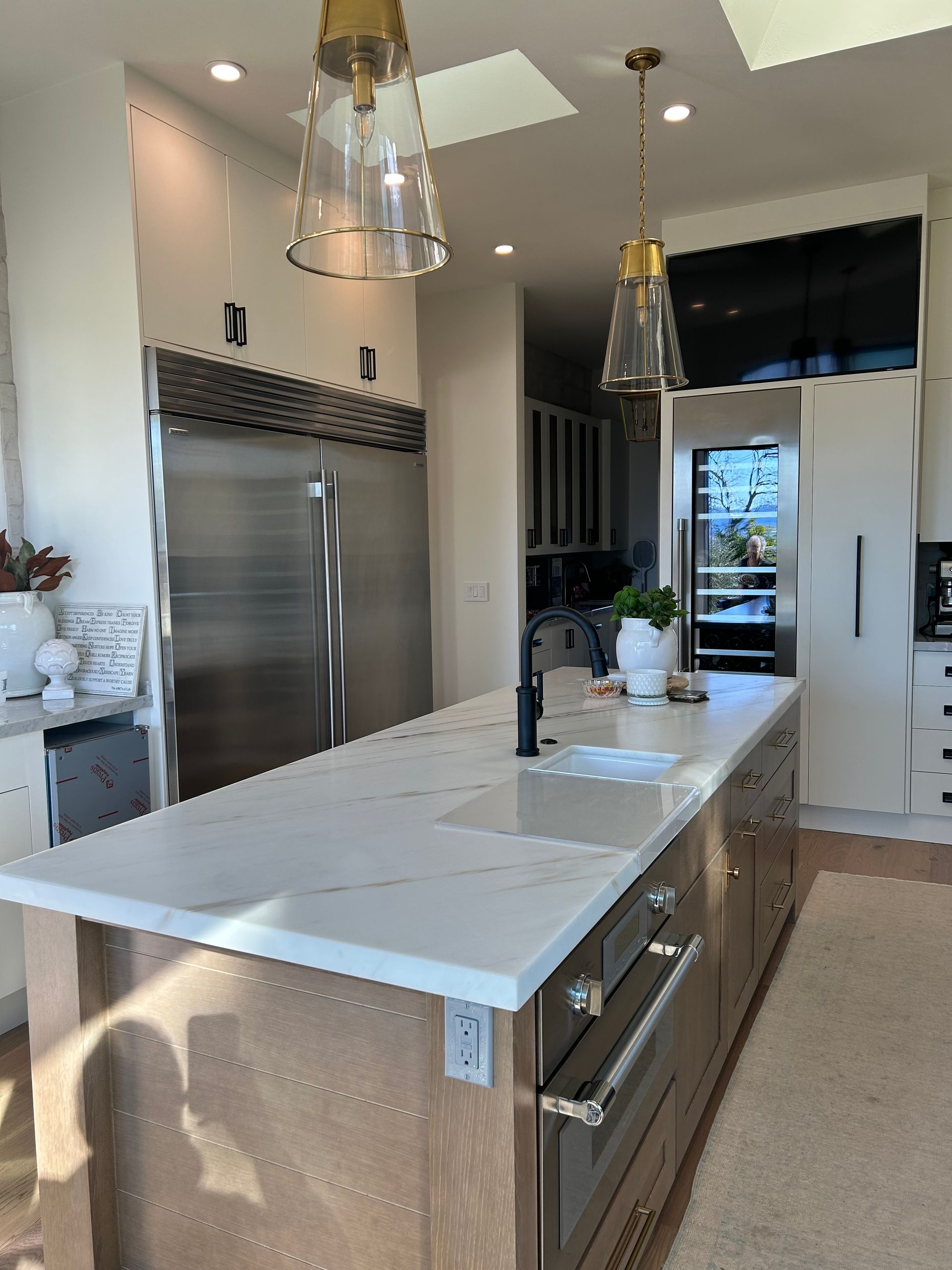 Modern kitchen with a large island, stainless steel appliances, and pendant lights.