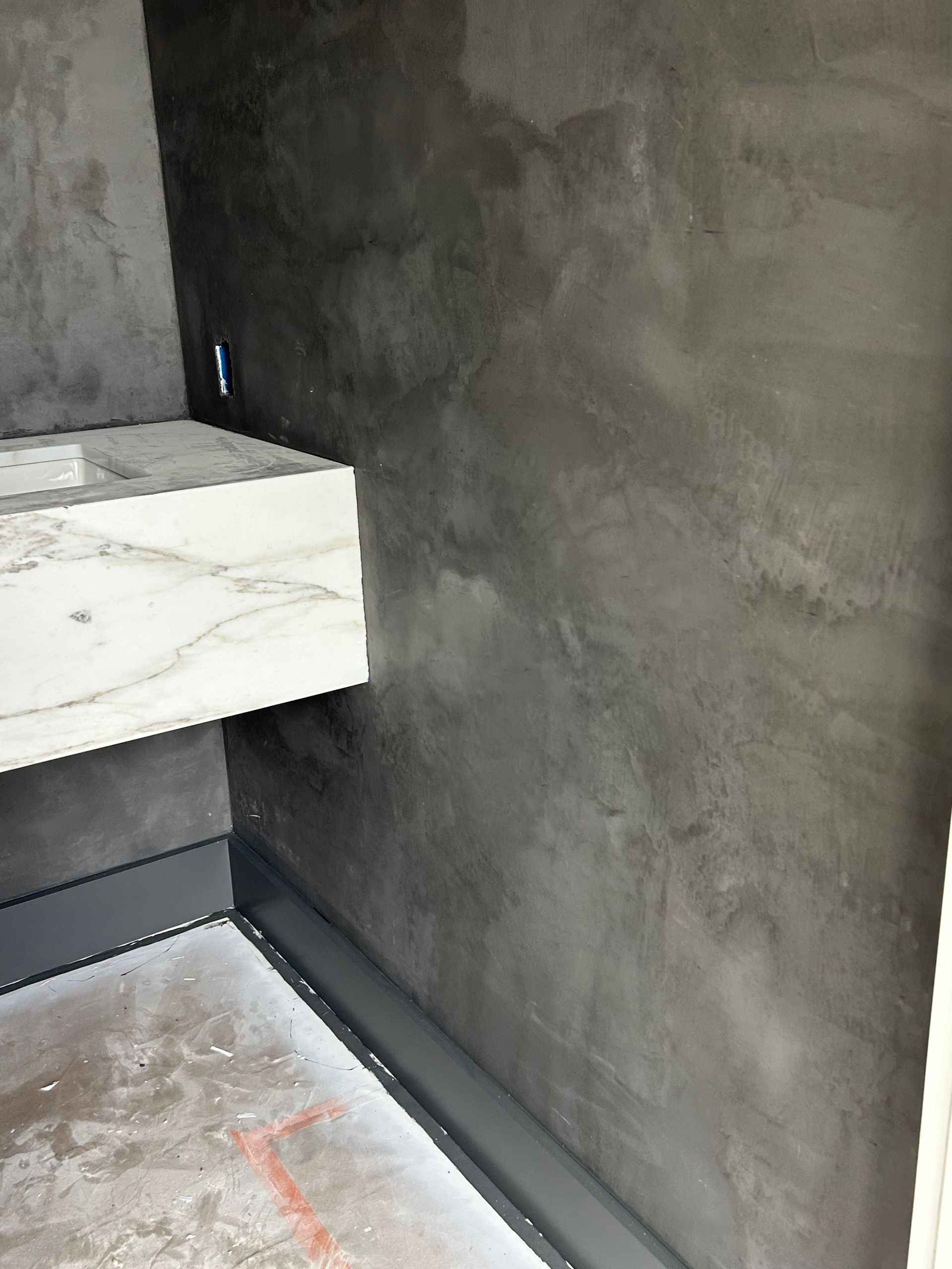 Dark gray wall with marble countertop in a modern bathroom setting.