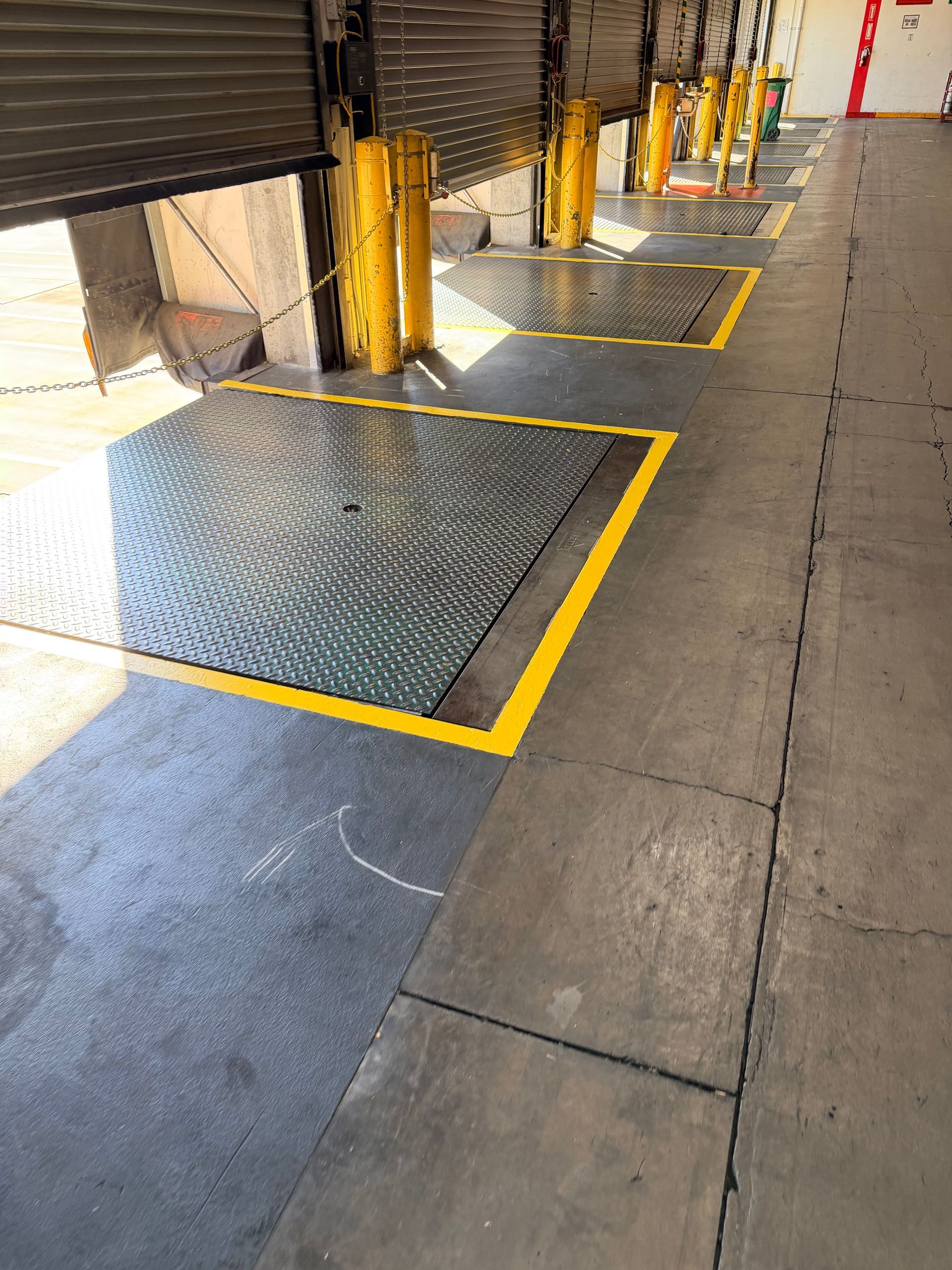Loading dock platforms with yellow borders and security bollards.