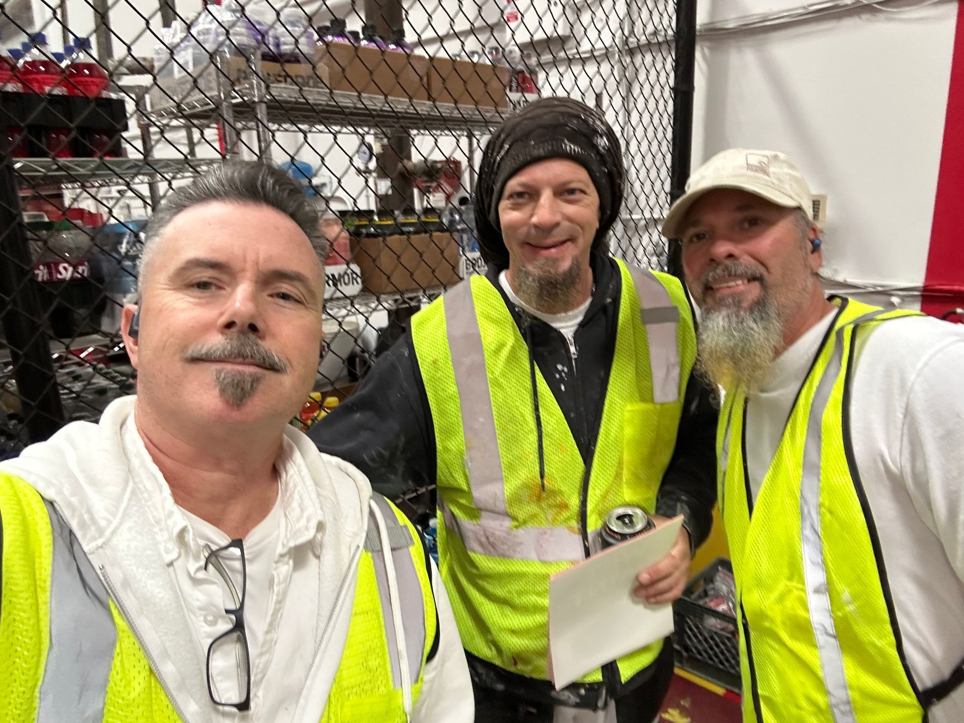 White house with a glass sunroom, manicured lawn, trimmed hedges, and small trees.