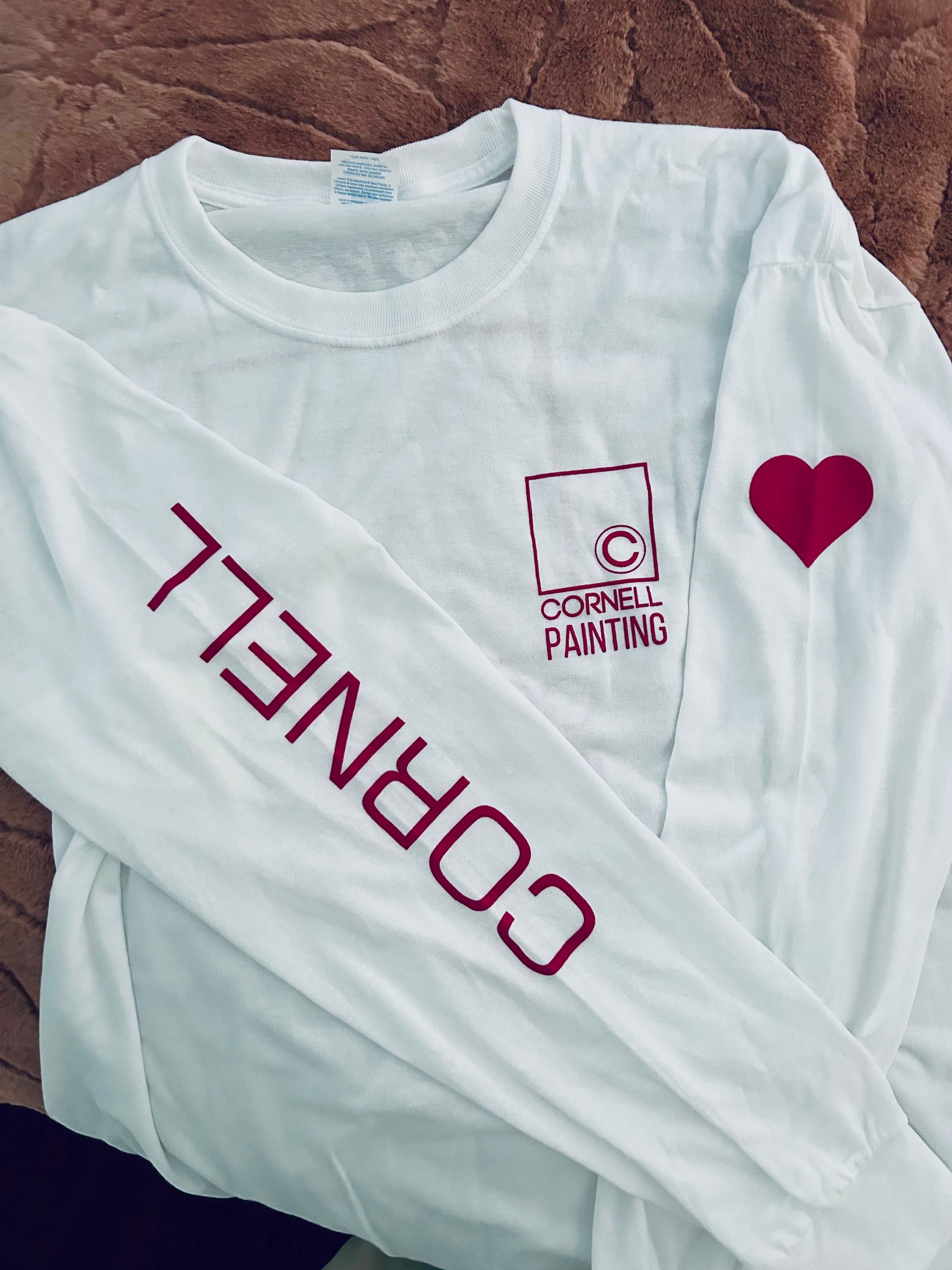 White Cornell sweatshirt with red text and logo. Heart on one sleeve.