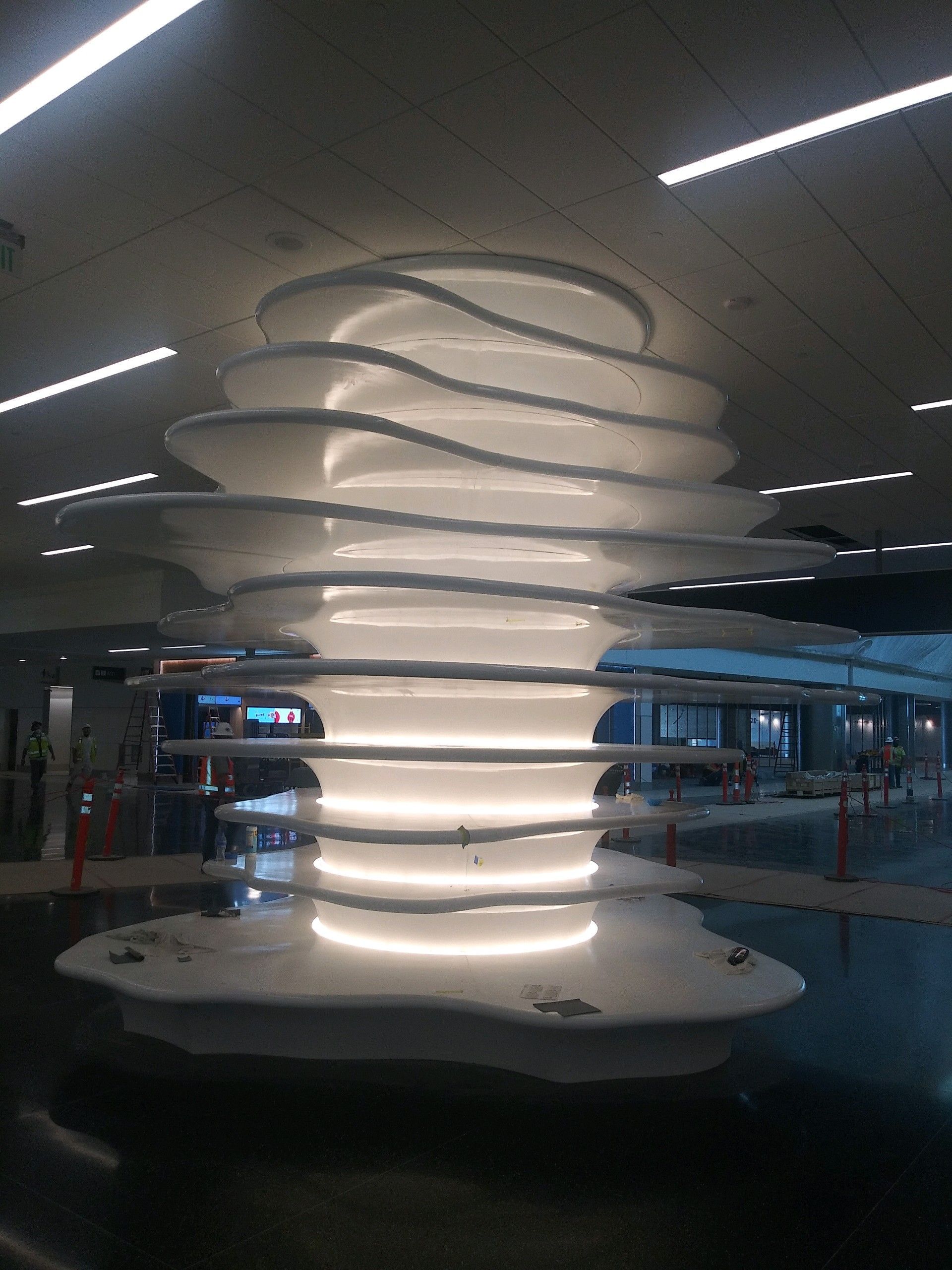 A church stage under renovation. The stage is covered in plastic. Black backdrop. Brown carpeted floor.