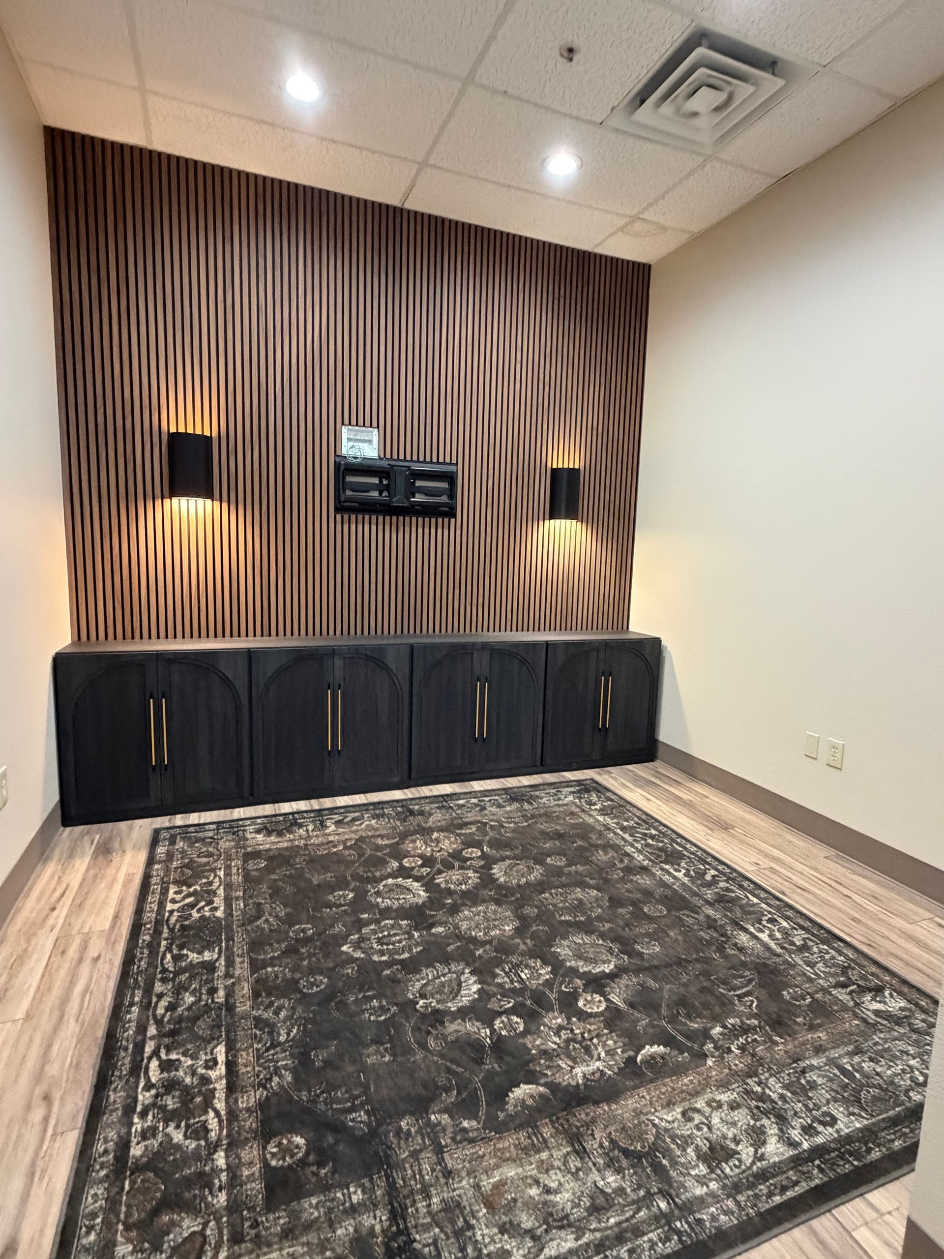 Construction site: interior of a building with covered equipment, concrete walls, and brown flooring.