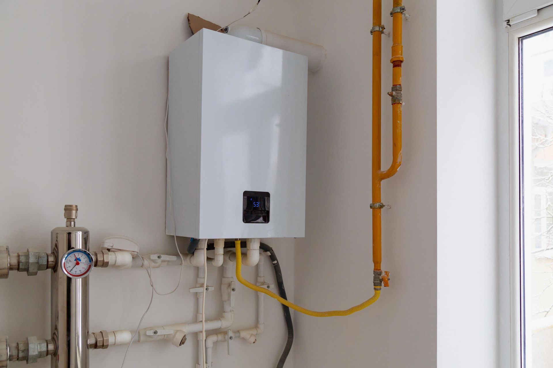 Gas water heater with pipes and valves in a room, showcasing efficient heating solutions