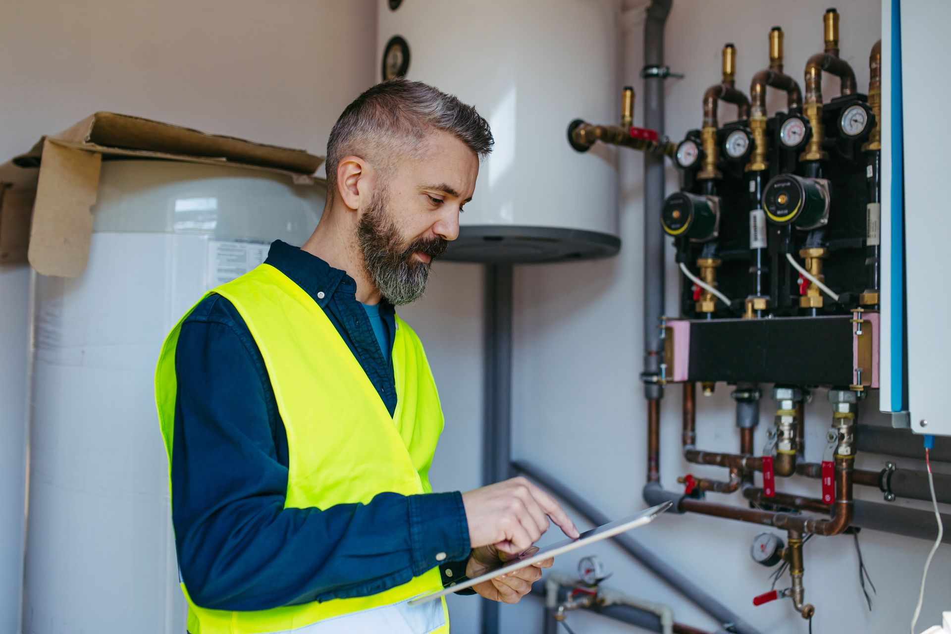 Technician inspecting boiler system during professional heating repair service at home.