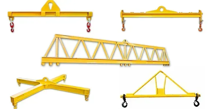 Una collezione di cinque diverse travi di sollevamento e telai di sollevamento industriali di colore giallo per attrezzature di sollevamento gru.