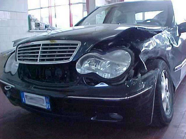 Una mercedes nera con il frontale danneggiato
