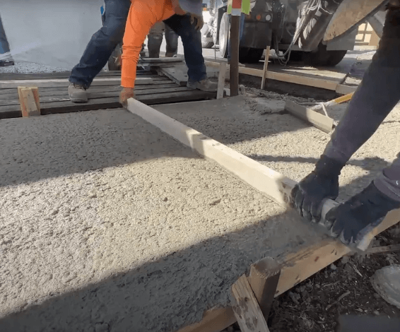 Workers smoothing wet concrete for a patio in Oswego, IL
