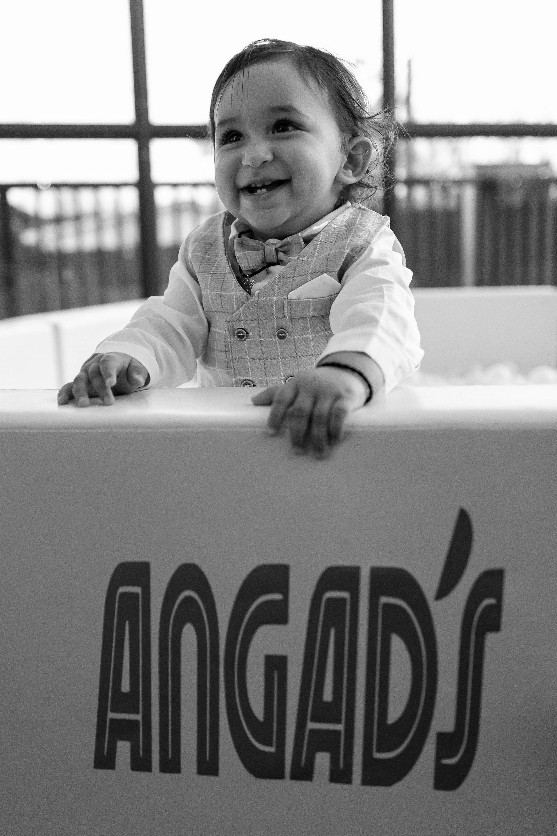 A baby is sitting in a tub that says angad 's on it