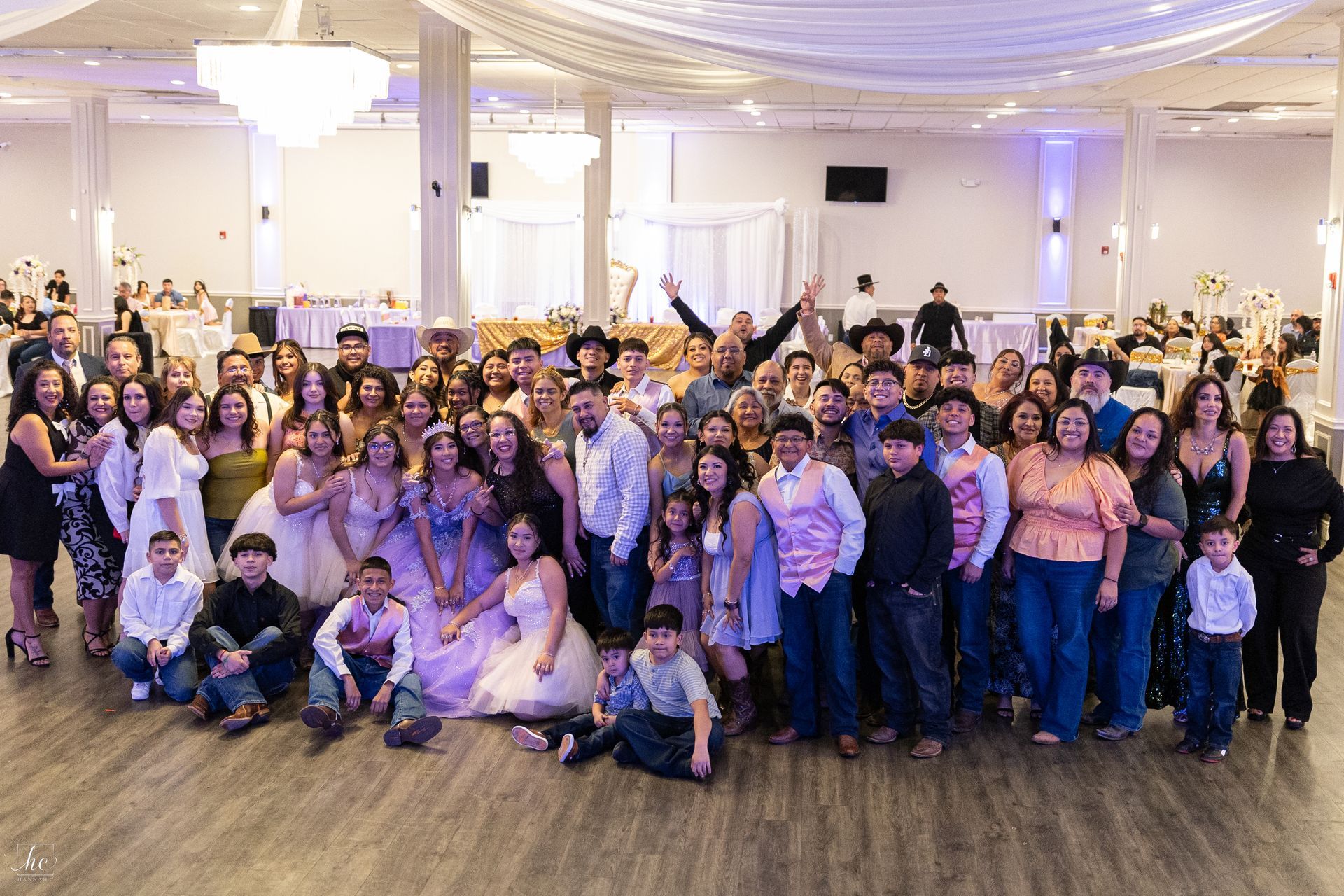 A large group of people are posing for a picture in a ballroom.