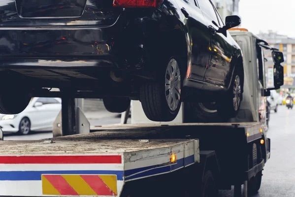 A car is being towed by a tow truck.