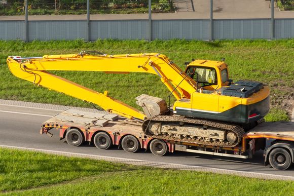 A bulldozer and an excavator are sitting next to each other on a white background.