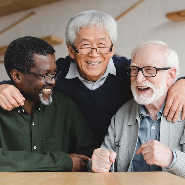 Three older men are posing for a picture looking happy.