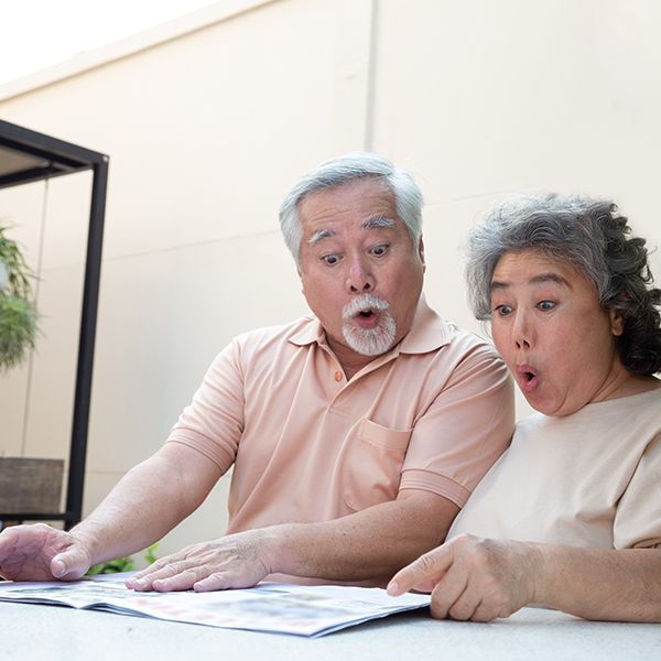 An older man and woman amazed at a newsletter.