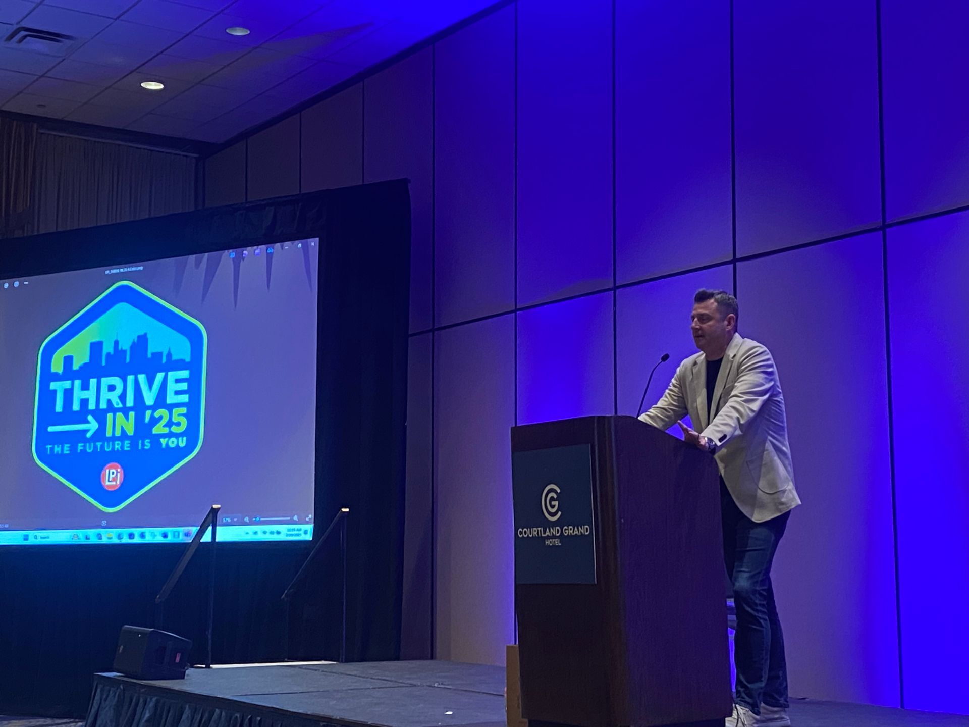 A man on stage presenting to an audience