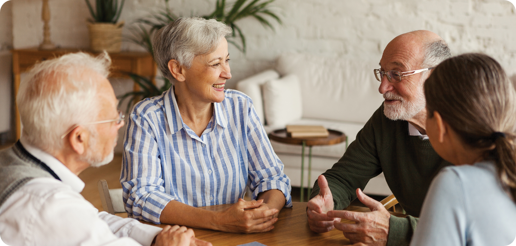 A group of people are sitting around a table having a conversation.