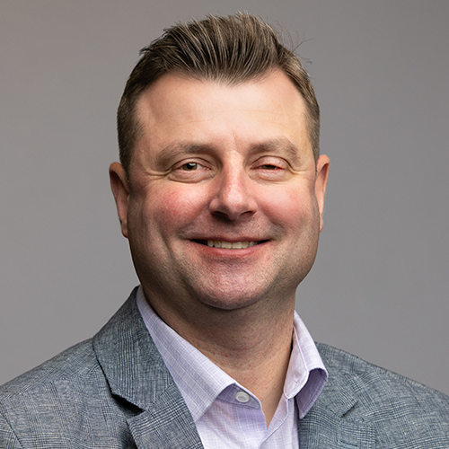 A man in a suit and tie is smiling for the camera.