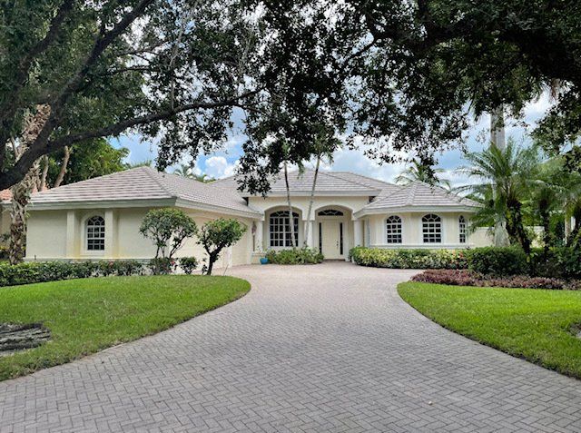 A large white house with a new roof installed by Four Peaks Roofing in Naples