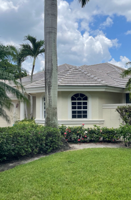 A white house with a new roof installed by Four Peaks Roofing in Cape Coral