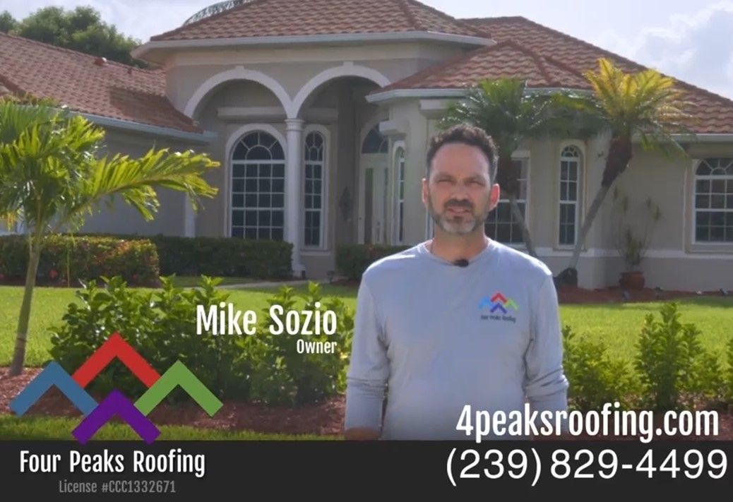 Mike Sozio is standing in front of a house with a new roof installed by Four Peaks Roofing