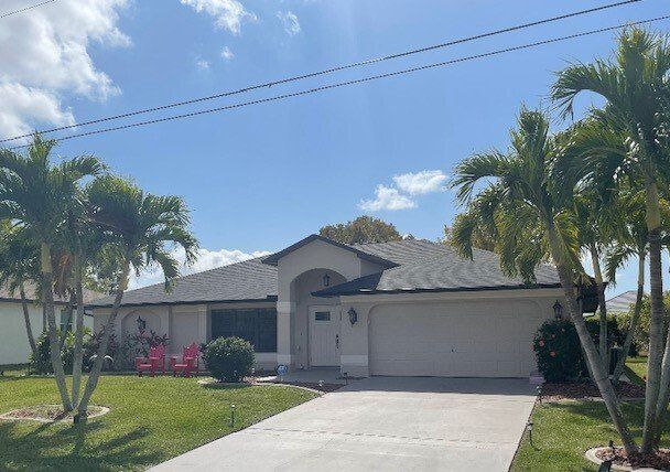 A white house in Estero with a new roof built by Four Peaks Roofing
