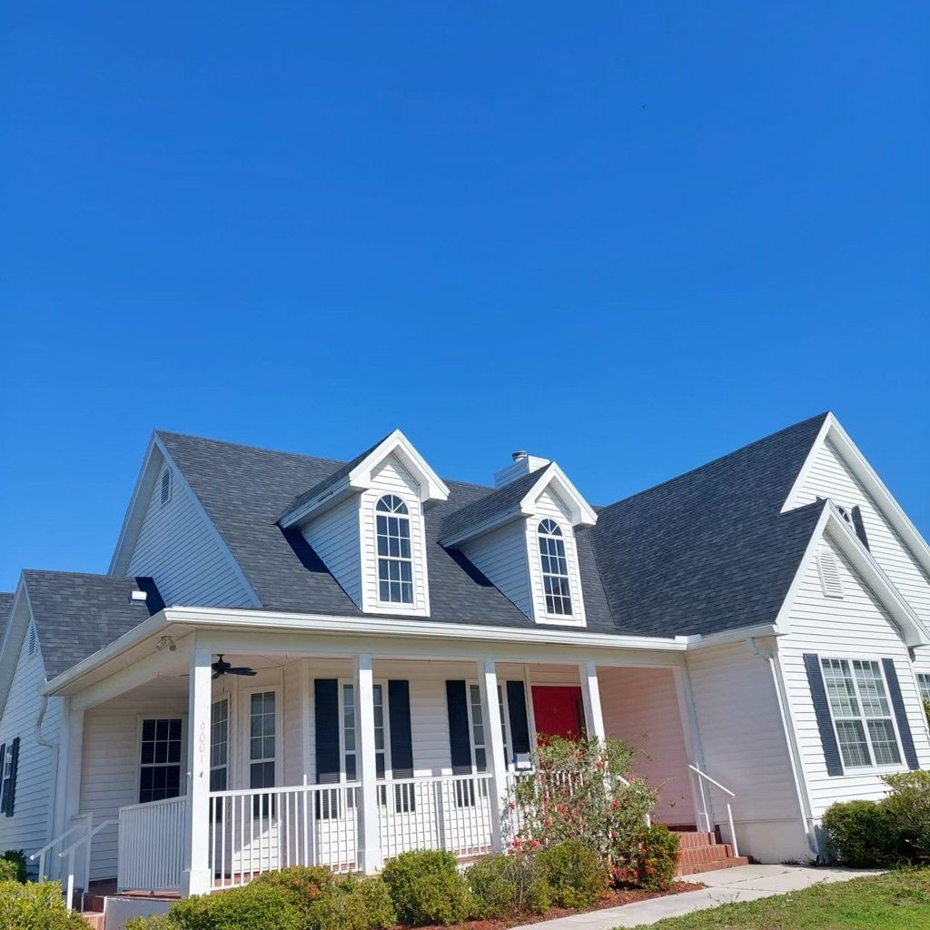 A white house with a black roof installed by Four Peaks Roofing in Fort Myers