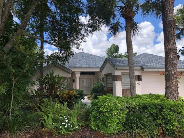 A white house with a new tile roof built by Four Peaks Roofing in Estero