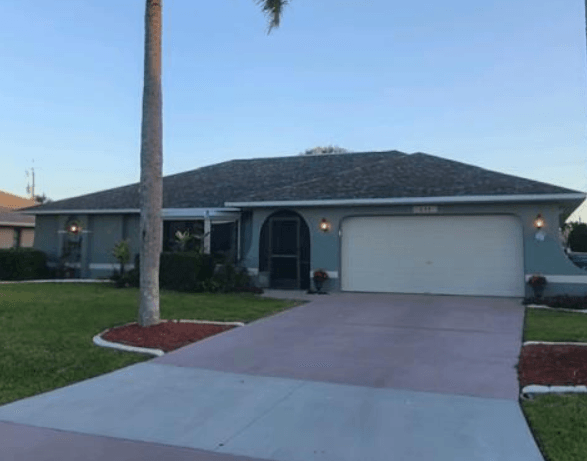 A blue house with a grey tile roof newly installed by Four Peaks Roofing in Cape Coral