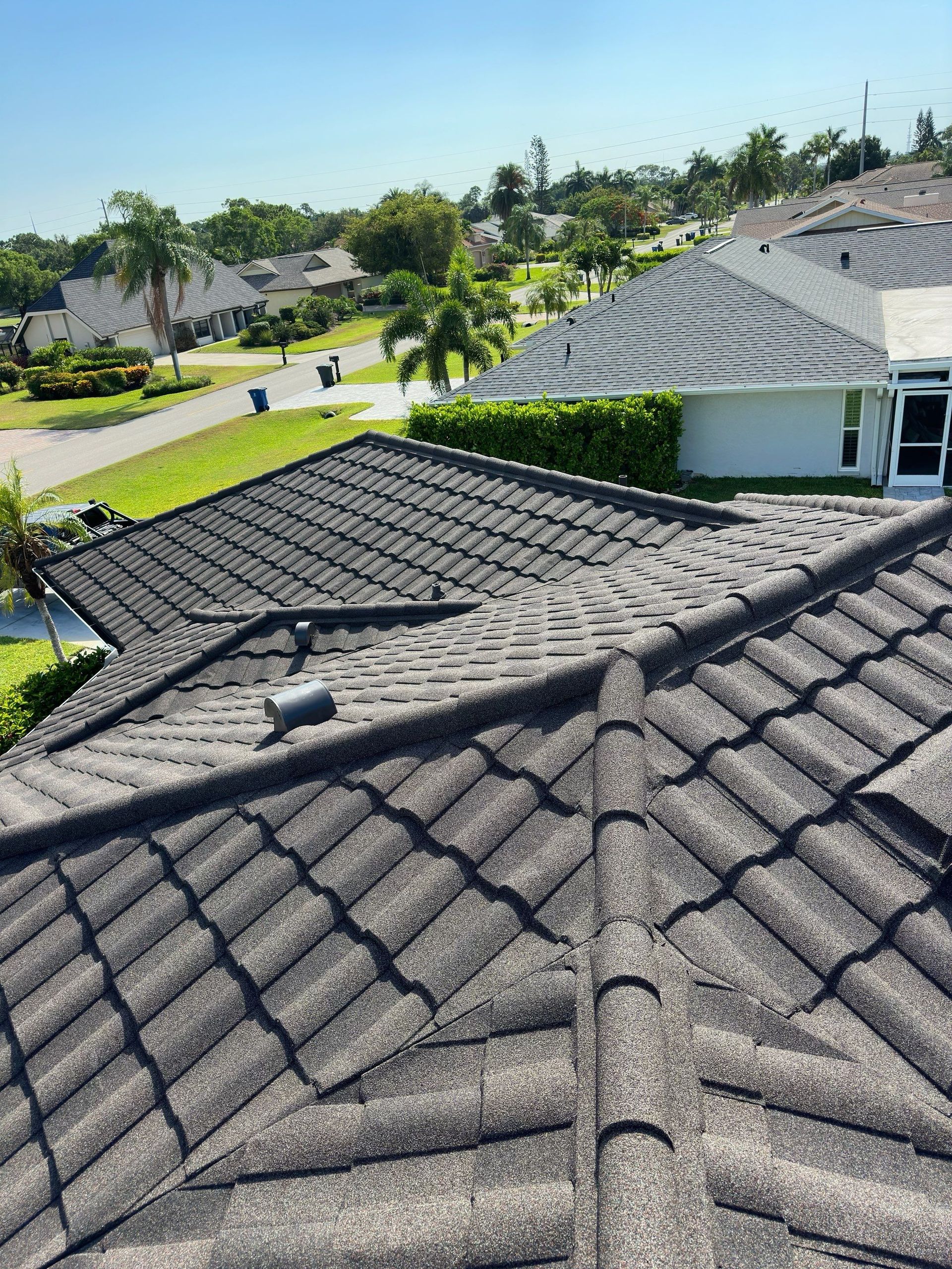 Gray tile roof with neighborhood view on a sunny day.