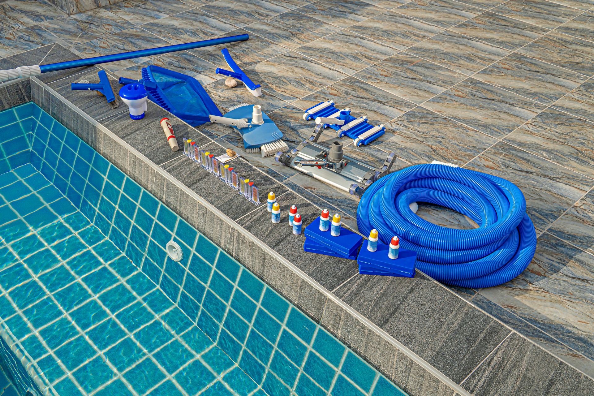 A swimming pool with a lot of cleaning equipment on the side of it.