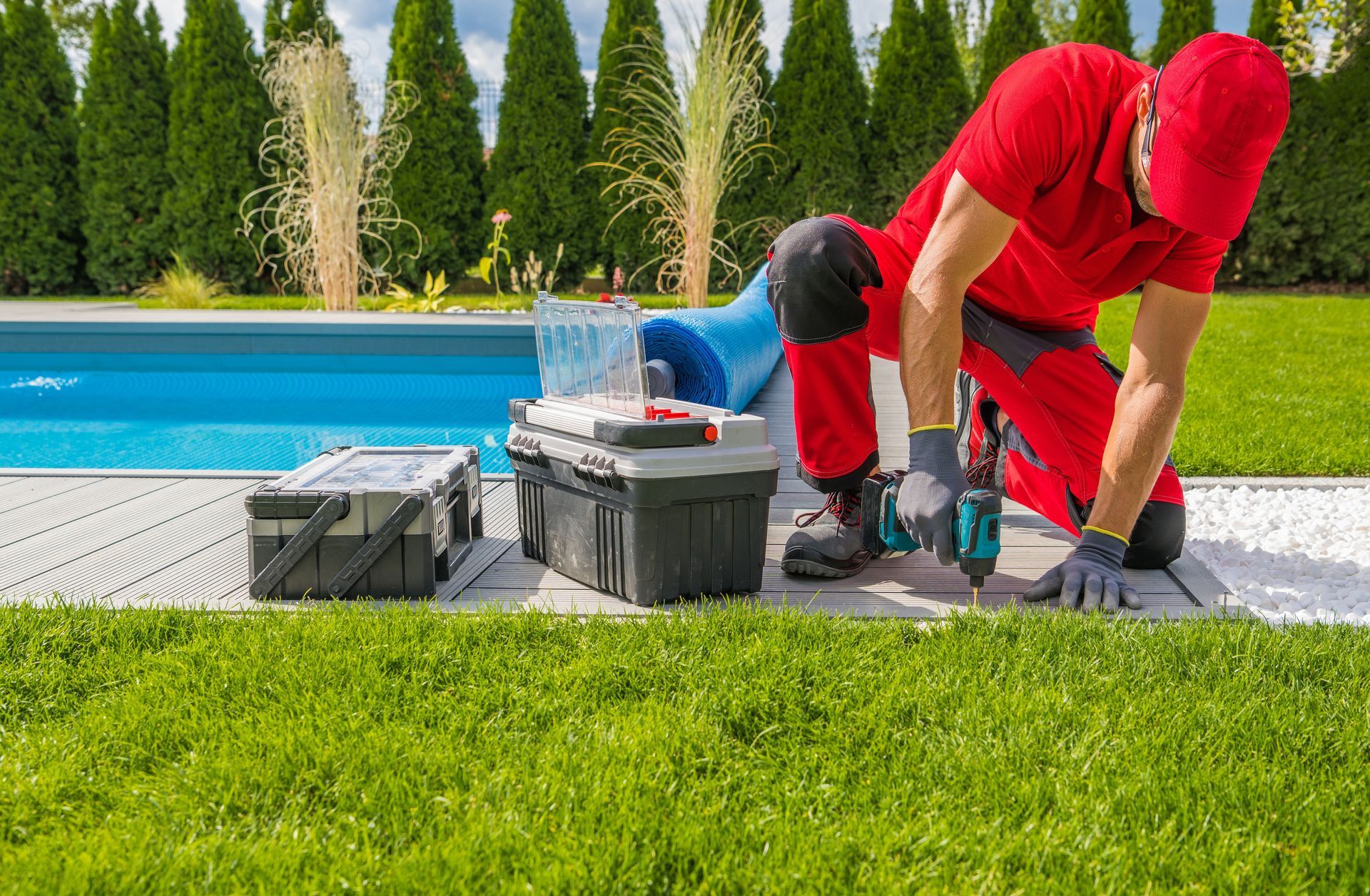 A man is using a drill to fix a swimming pool.