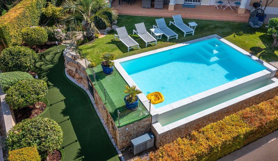 An aerial view of a large swimming pool surrounded by lawn chairs.