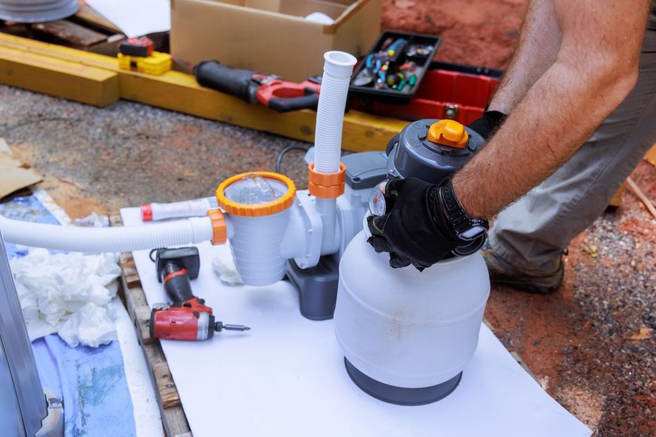 A man is working on a swimming pool filter.