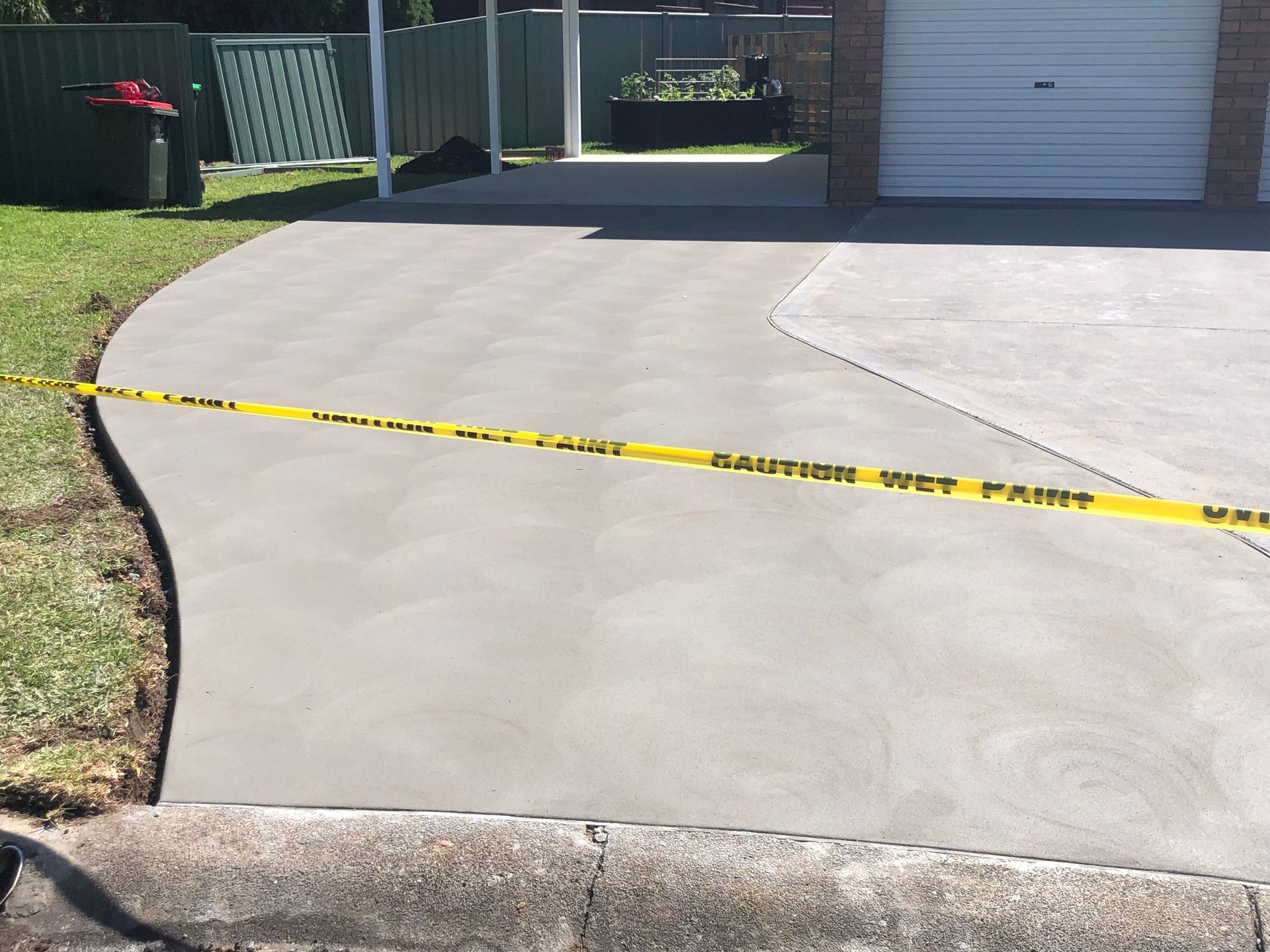 Newly Poured Concrete Driveway with Caution Tape — Rhyno’s Concreting In Old Bar, NSW
