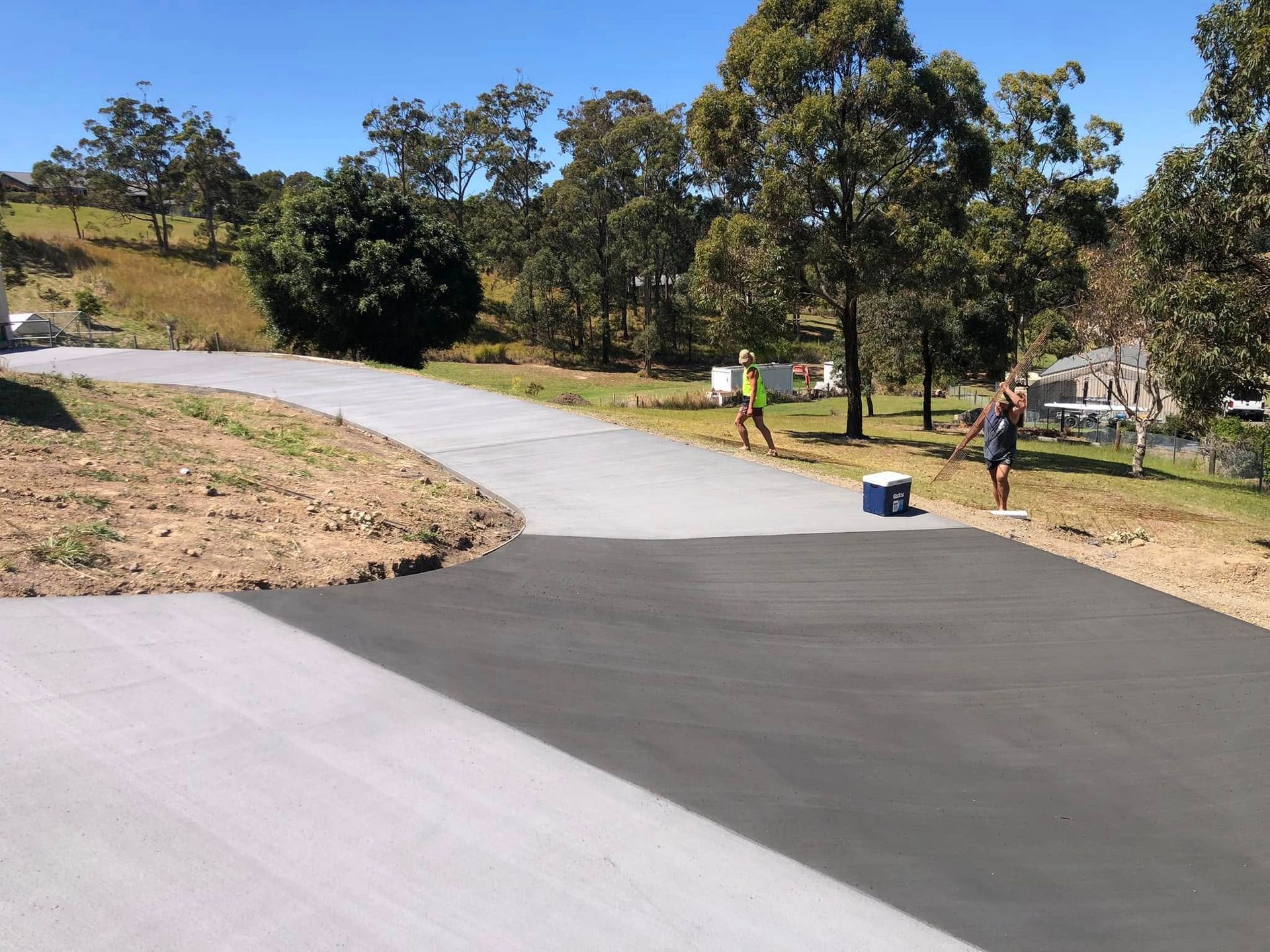 Two Workers Applying Sealant to A Newly Paved Driveway. One Is Rolling, the Other Standing Nearby — Rhyno’s Concreting In Old Bar, NSW