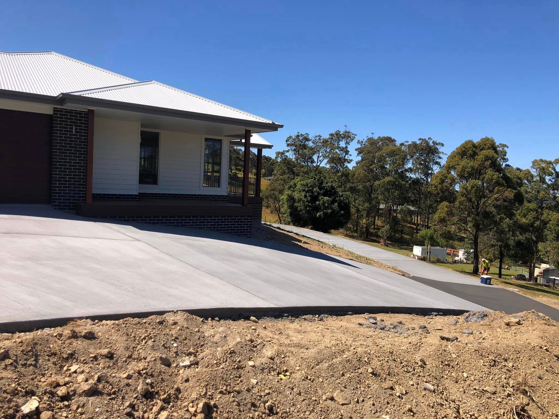 Newly Constructed House with Concrete Driveway on A Sunny Day — Rhyno’s Concreting In Old Bar, NSW