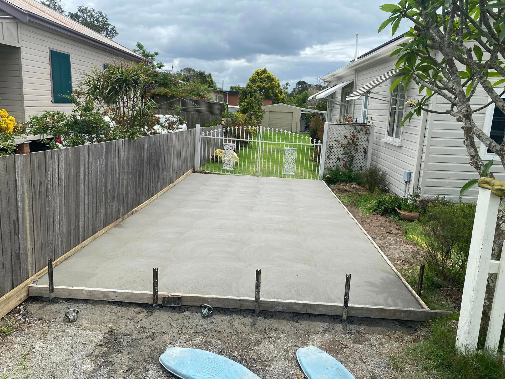 Freshly Poured Concrete Slab Bordered by Wooden Formwork in A Backyard Setting — Rhyno’s Concreting In Old Bar, NSW