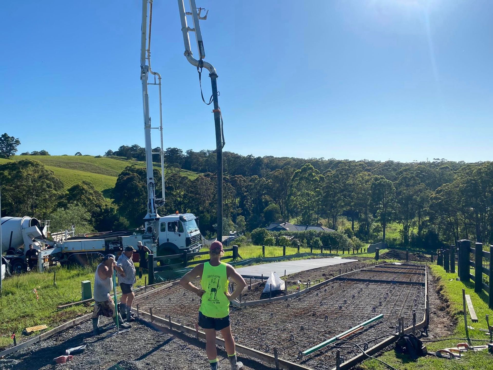 Concrete Pour on A Rural Construction Site. Workers Stand Near Foundation Forms. a Pump Truck Extends Its Boom. Sunny Day — Rhyno’s Concreting In Old Bar, NSW