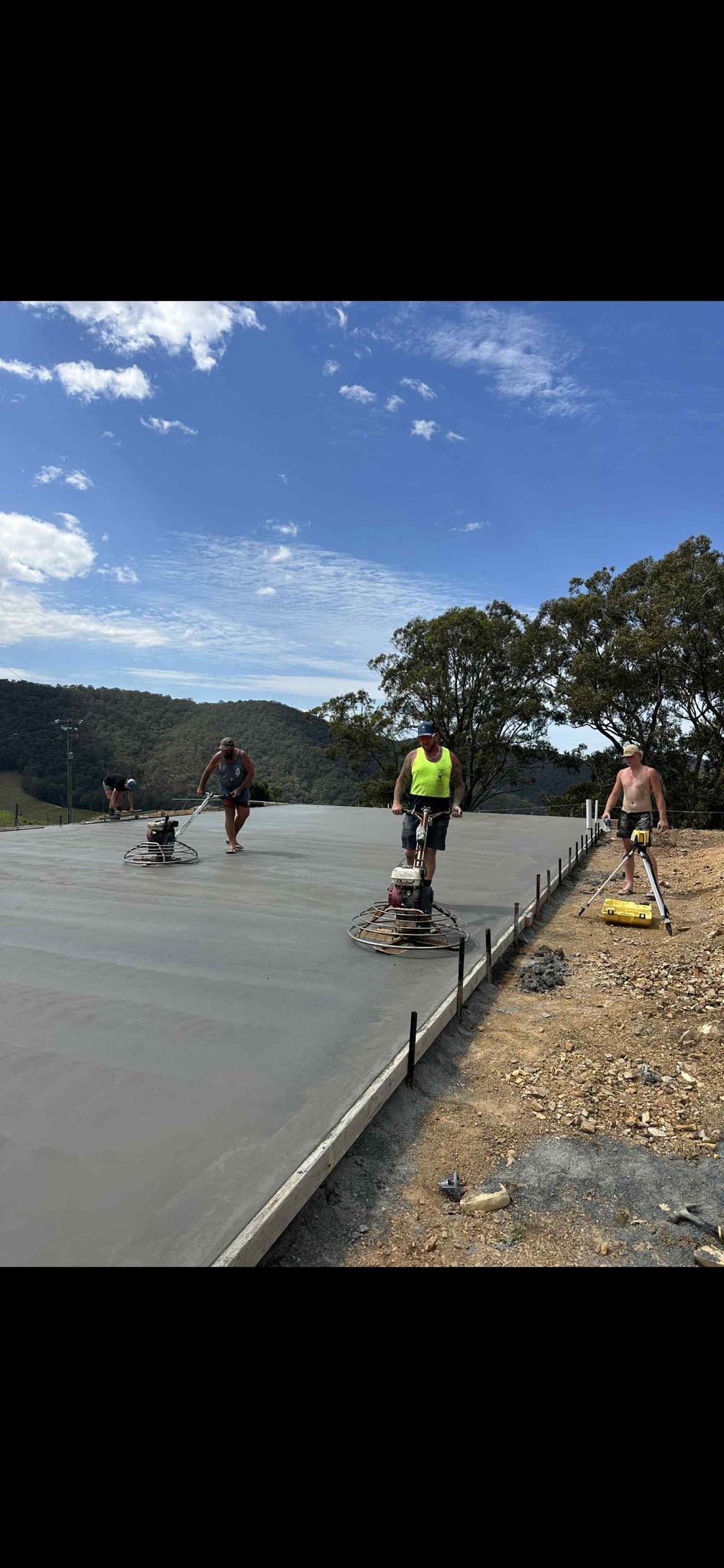Construction Workers Smoothing Wet Concrete on a Road — Rhyno’s Concreting In Old Bar, NSW