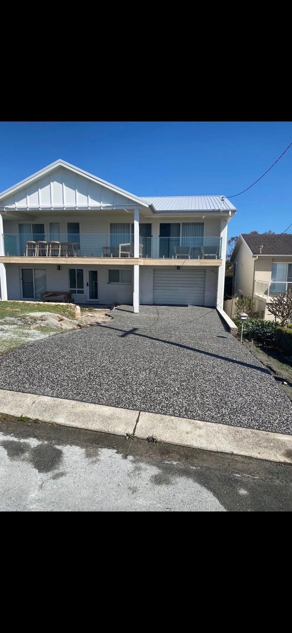 Two-story White House With Balconies, a Gravel Driveway, and a Garage — Rhyno’s Concreting In Old Bar, NSW