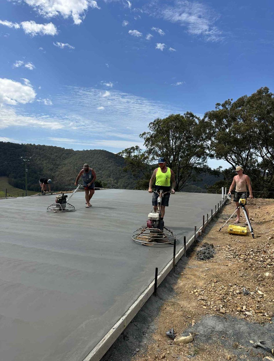 Workers Smoothing Concrete on A Road, a Blue Sky Overhead — Rhyno’s Concreting In Old Bar, NSW